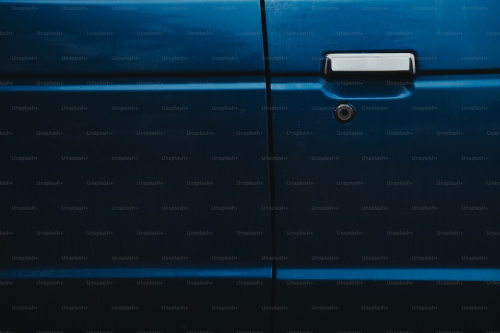 Un primer plano de la manija azul de la puerta de un coche