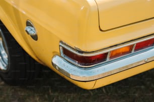 a close up of the tail end of a yellow car