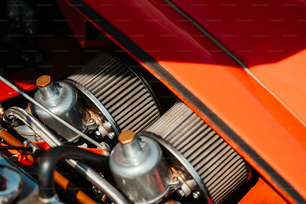 Un primer plano del motor de un deportivo naranja