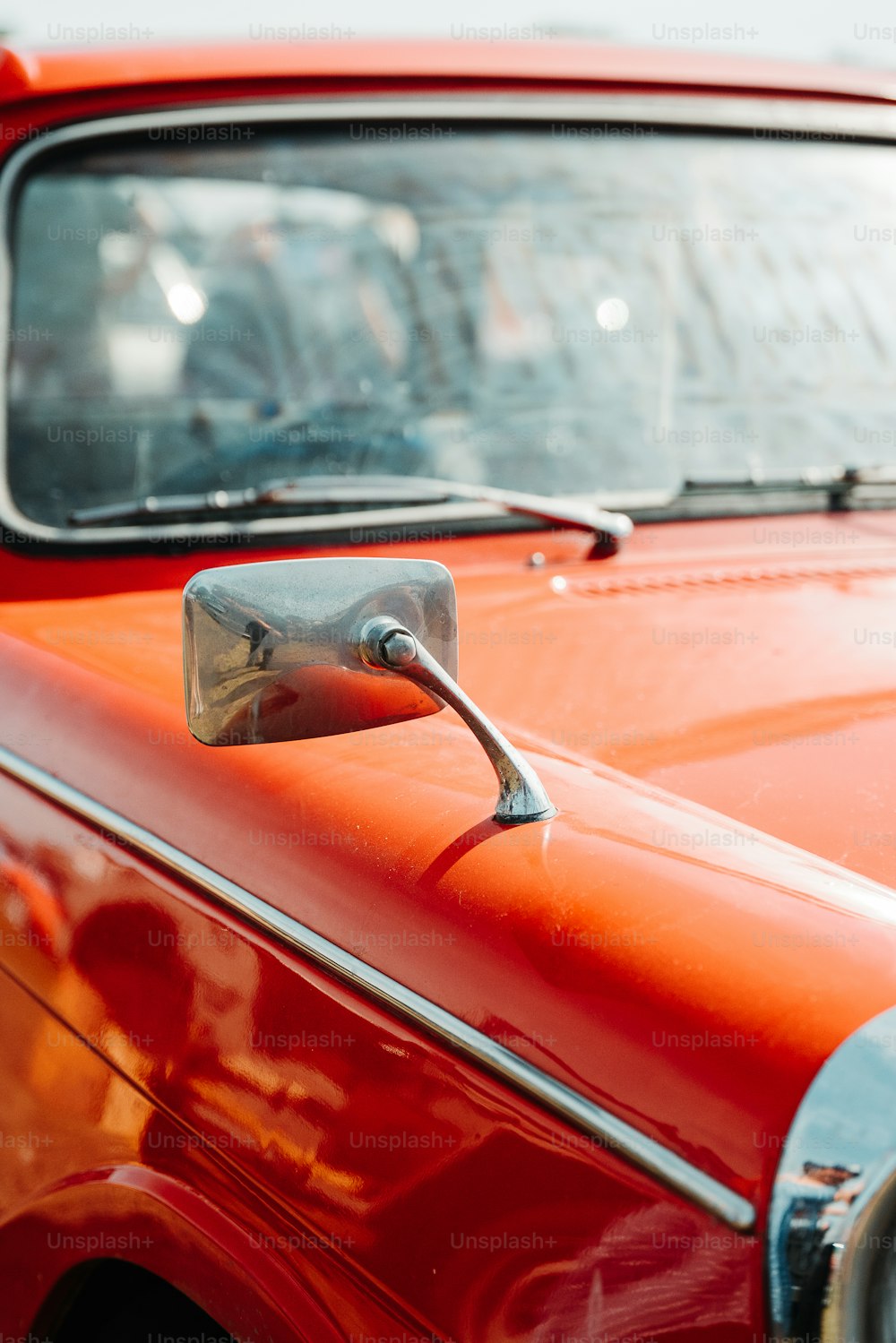 a close up of a red car with a mirror