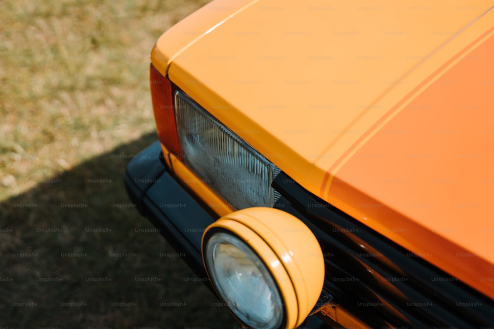 Un primer plano de la parte delantera de un coche naranja