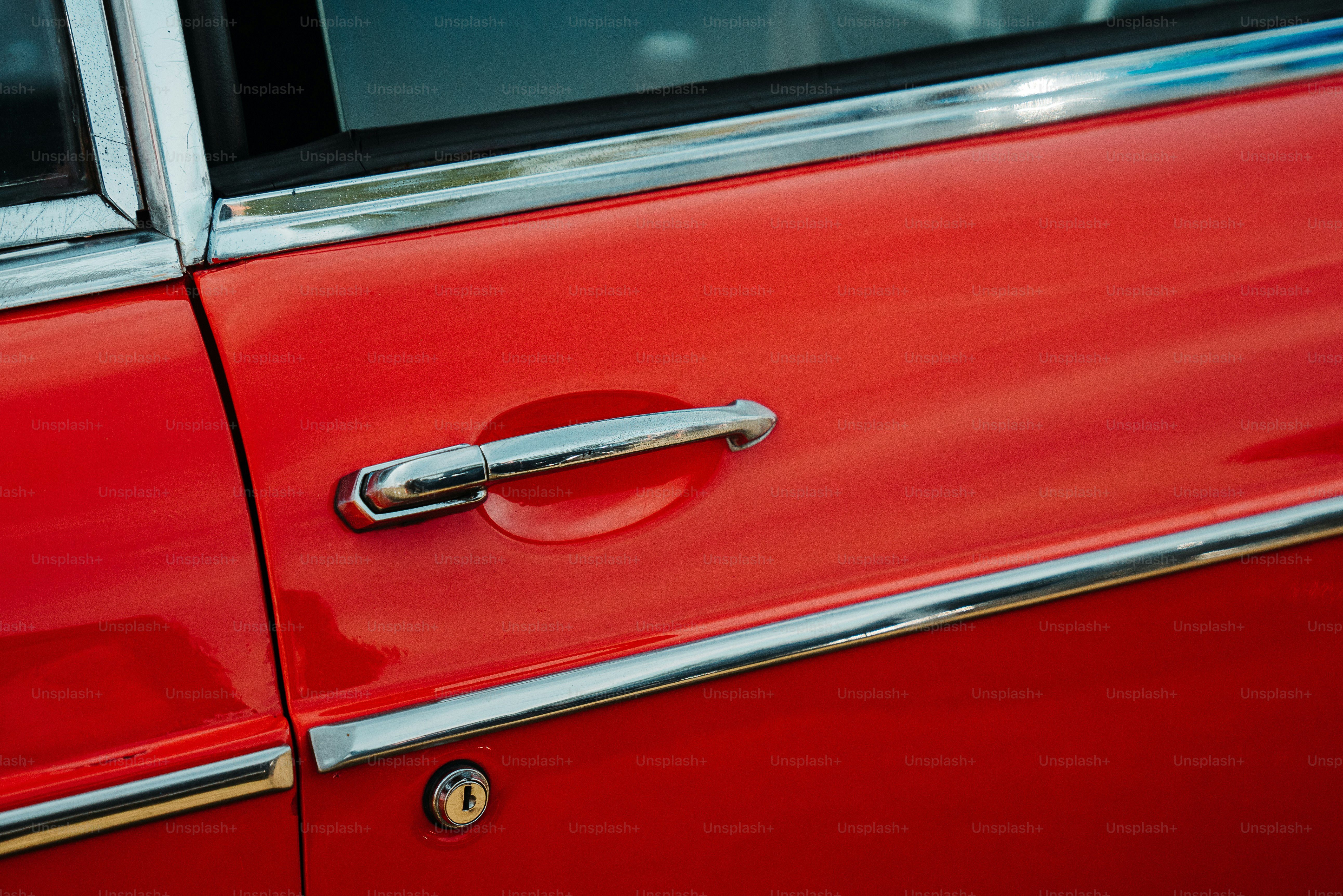 a close up of a door handle on a red car