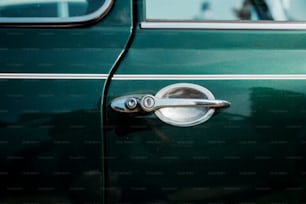 a close up of a door handle on a green car