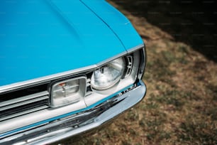 um close up da frente de um carro azul