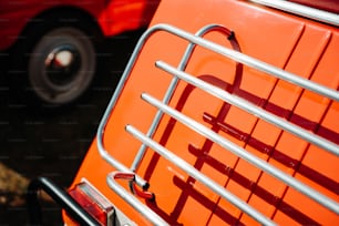 a close up of an orange vehicle with a metal grill