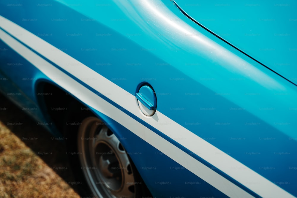 a close up of a blue car with white stripes