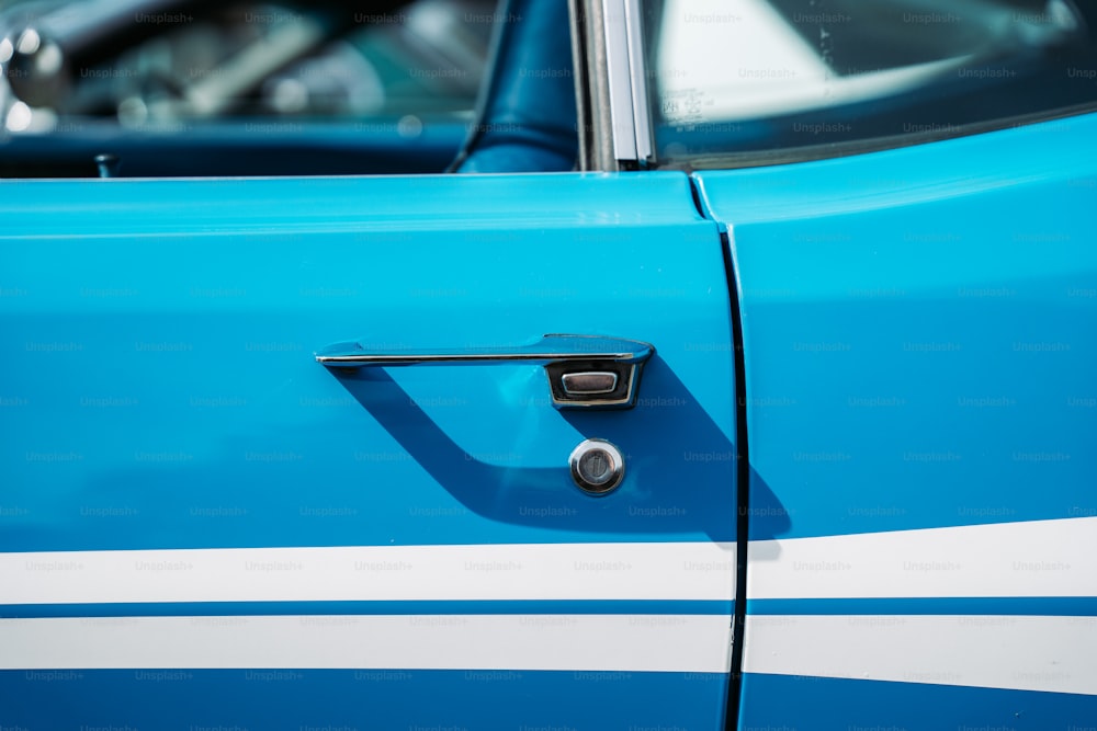 Un primer plano de la manija azul y blanca de la puerta de un automóvil