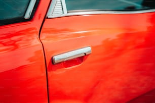 a close up of a red car door handle