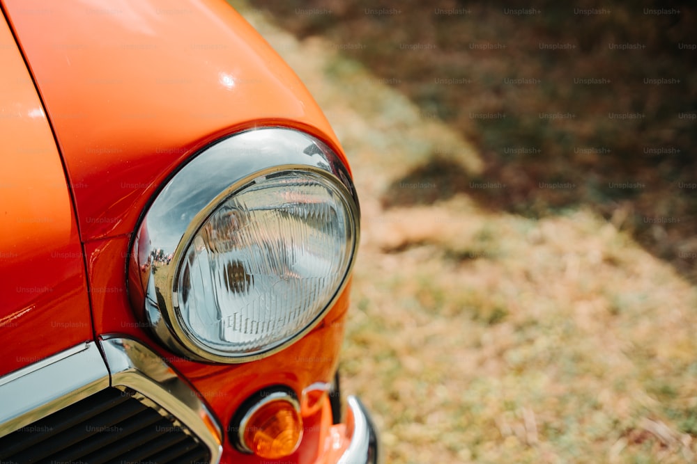 a close up of the headlight of an orange car