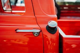a close up of a red truck door handle