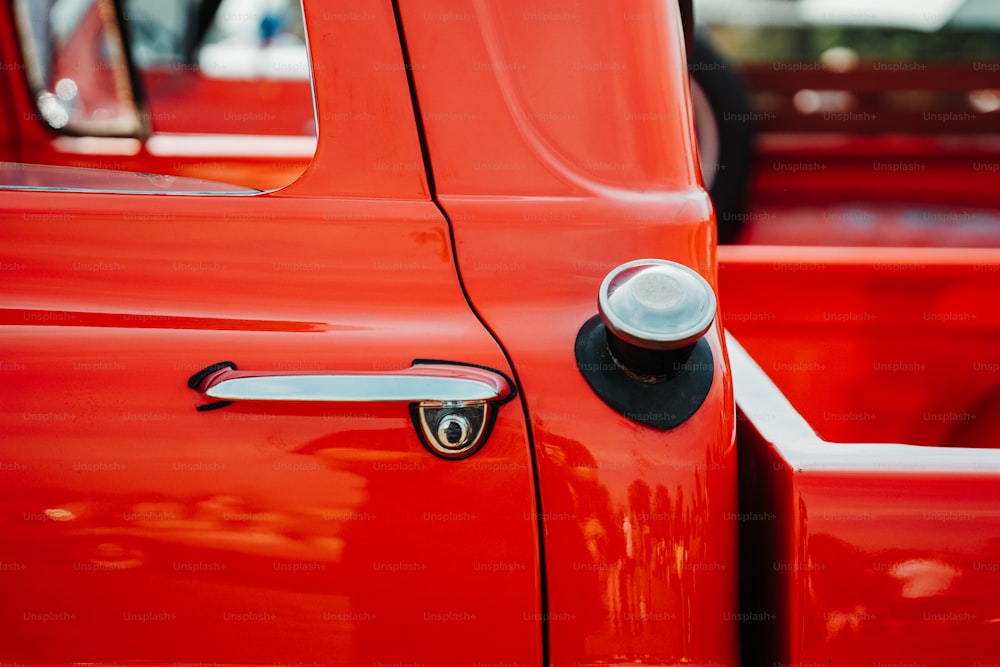 a close up of a red truck door handle