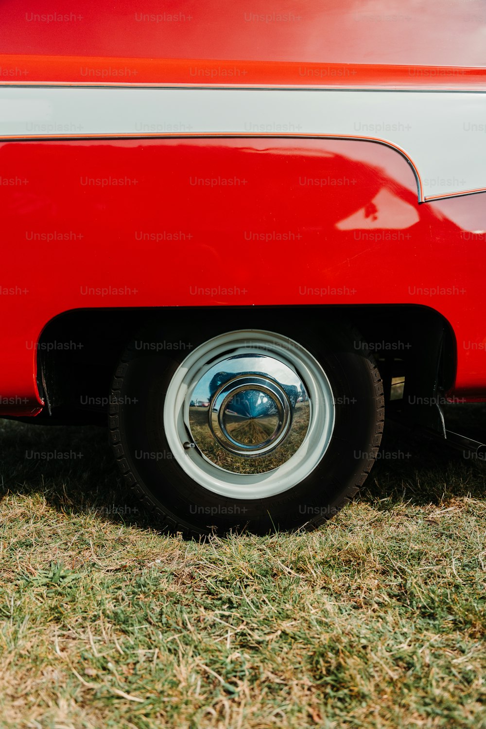 a close up of a red and white car tire