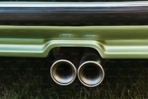 um close up de um carro verde com dois escapamentos