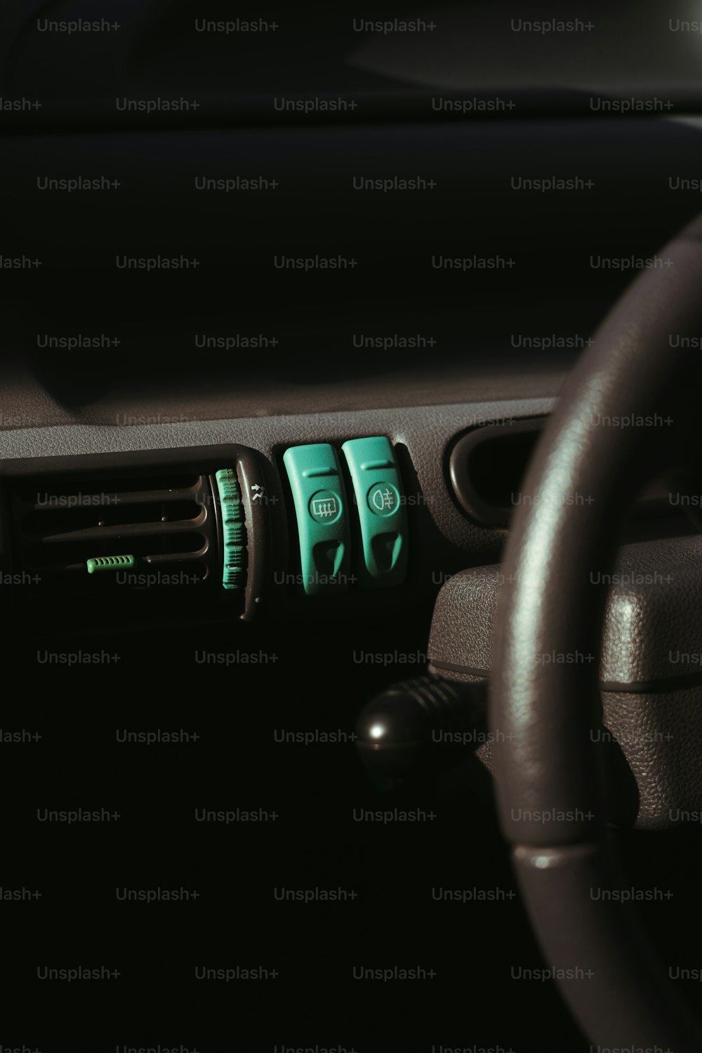 a car dashboard with a steering wheel and buttons