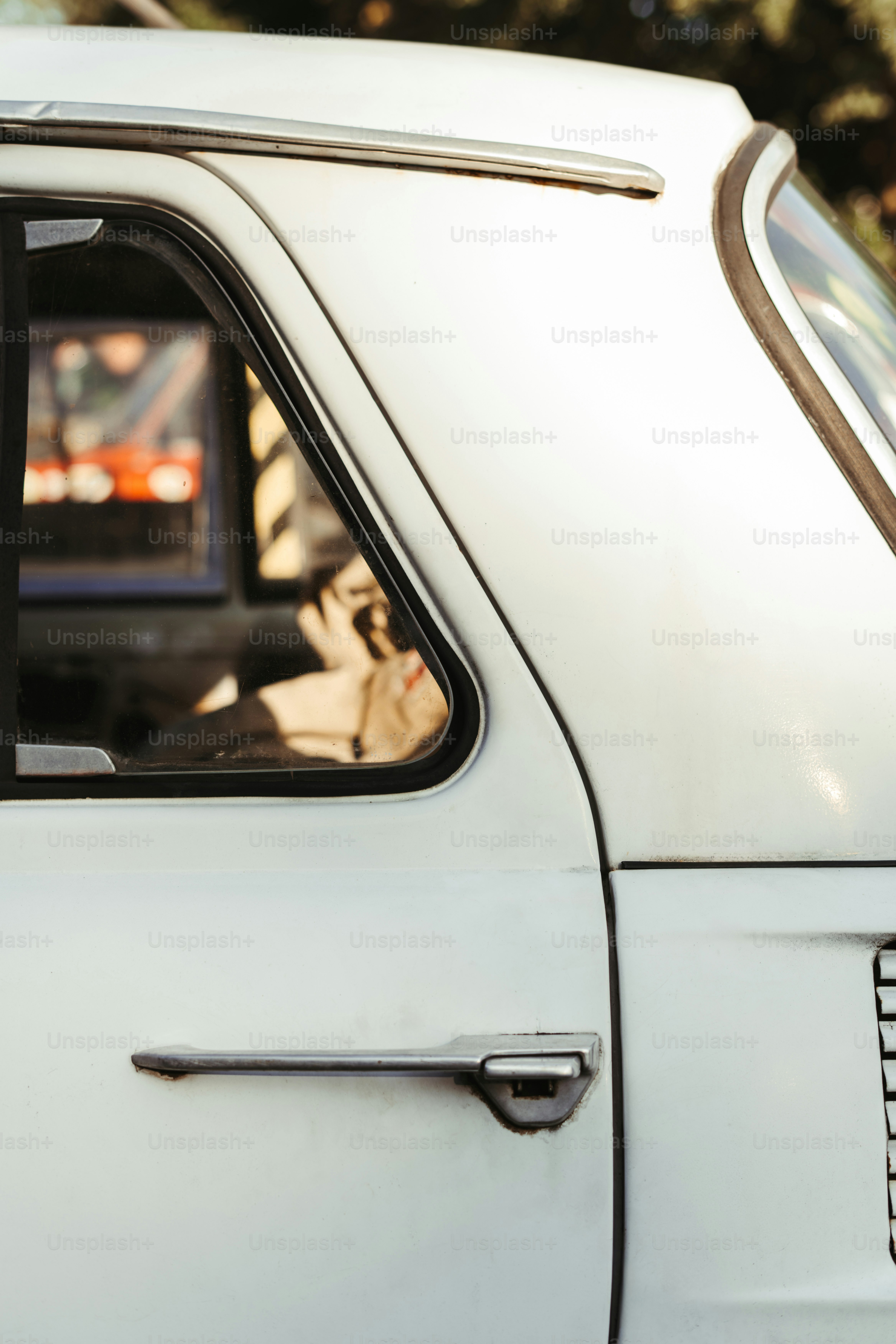 a close up of a white car with a dog in the window