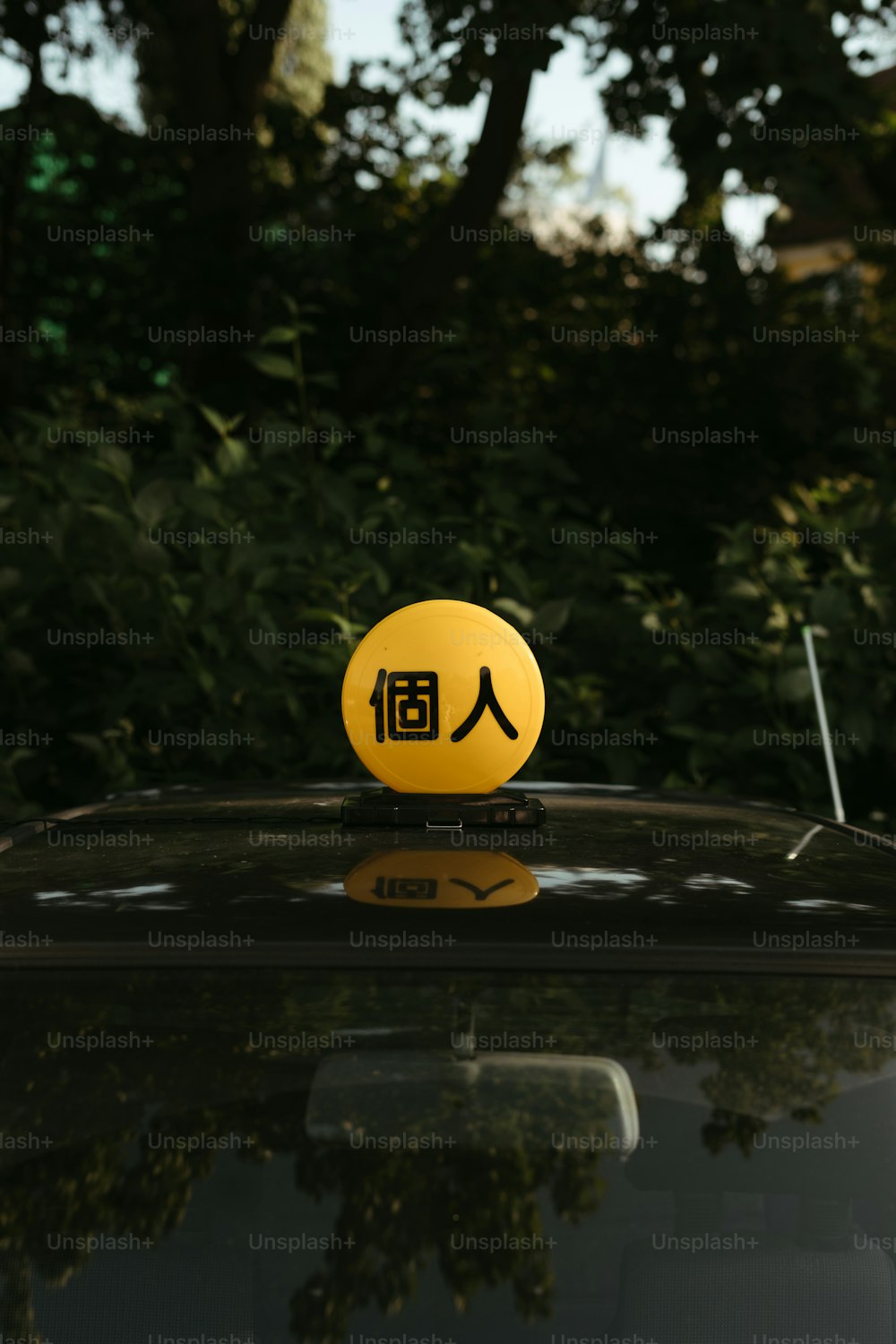 um rosto sorridente amarelo em cima de um carro preto