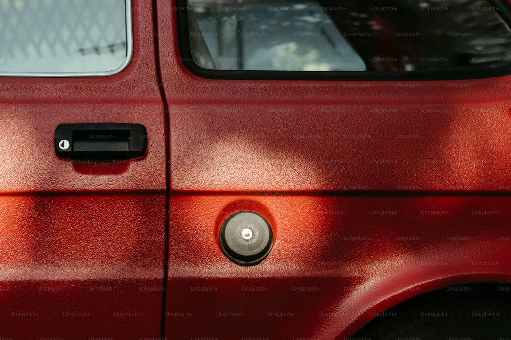 um close up da maçaneta da porta em uma van vermelha