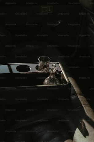 a black tray with a silver cup on top of it