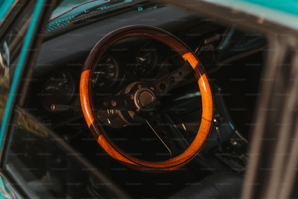 o interior de um carro com um volante de madeira