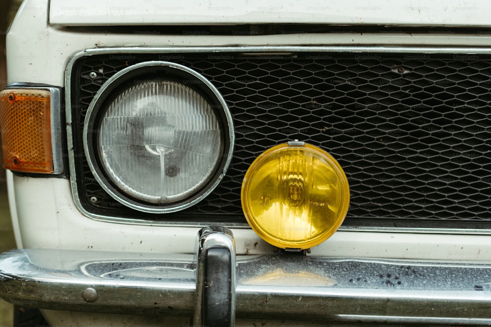 a close up of a yellow light on a white car