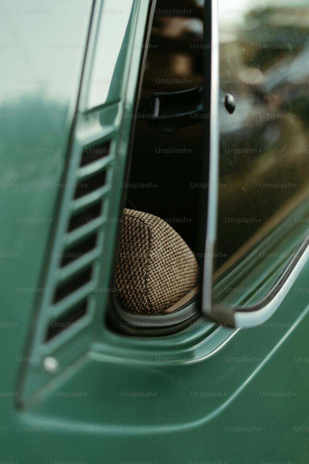 a brown ball sitting in the window of a green truck