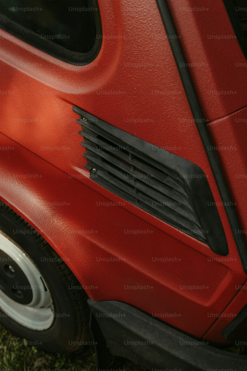 a close up of the side of a red car