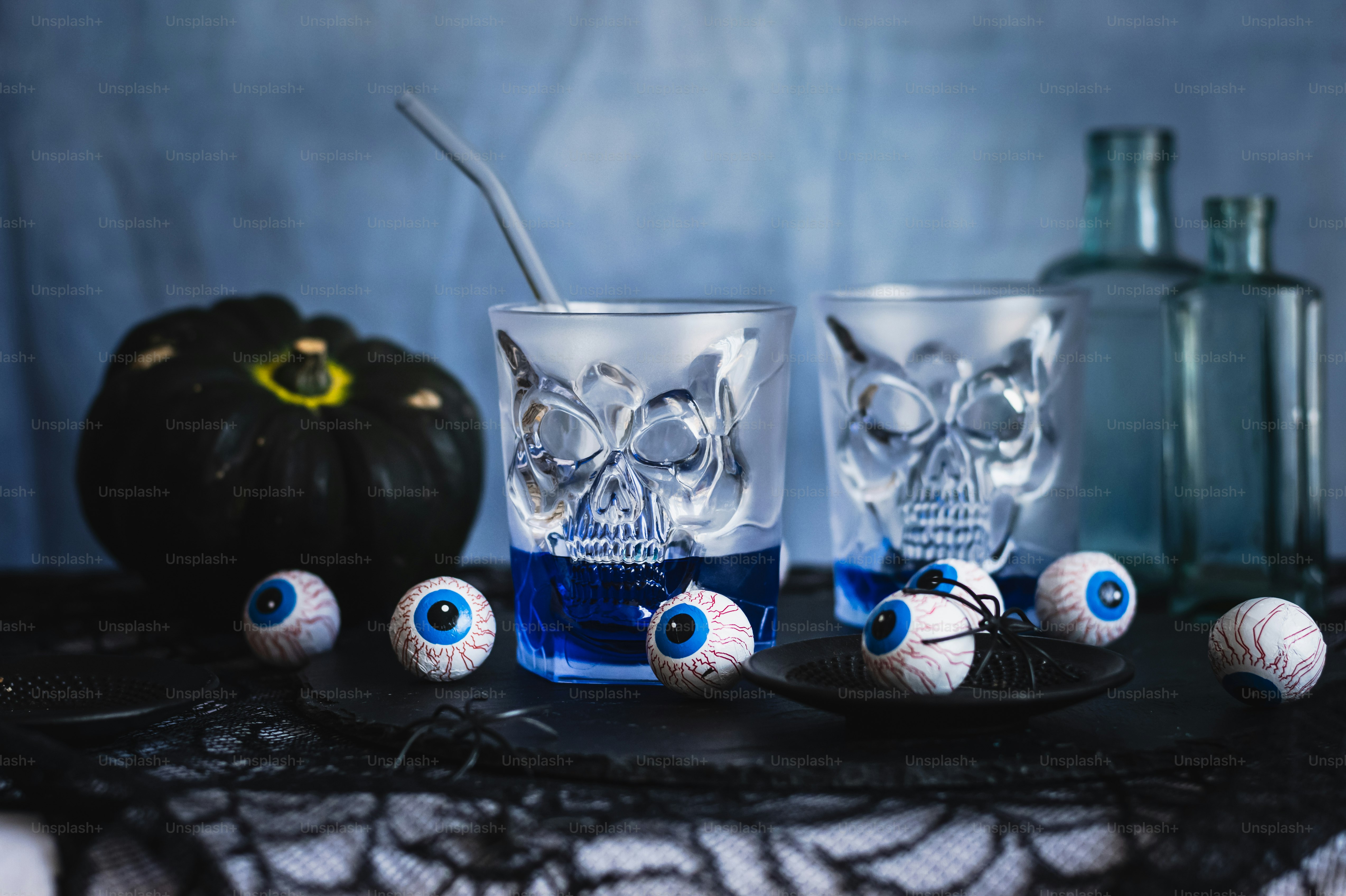 a table topped with two glasses filled with blue liquid