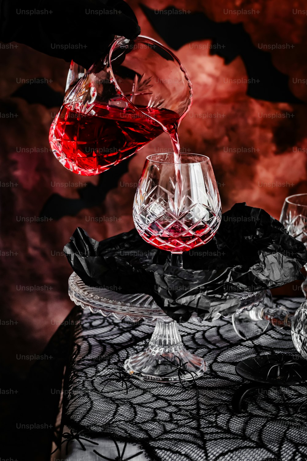 eine Person, die ein Glas Wein in ein Weinglas gießt
