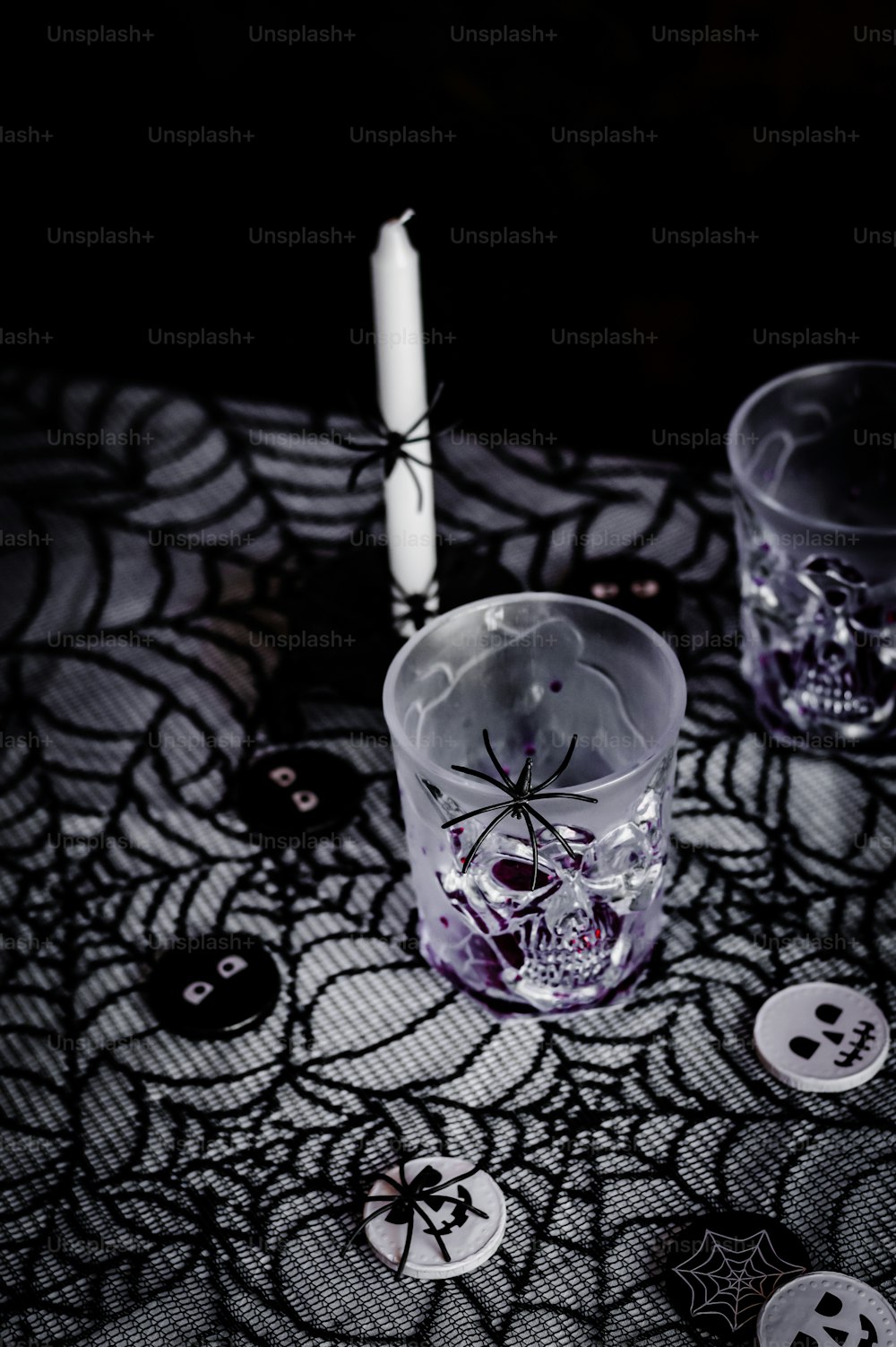 un vaso con una araña junto a una vela