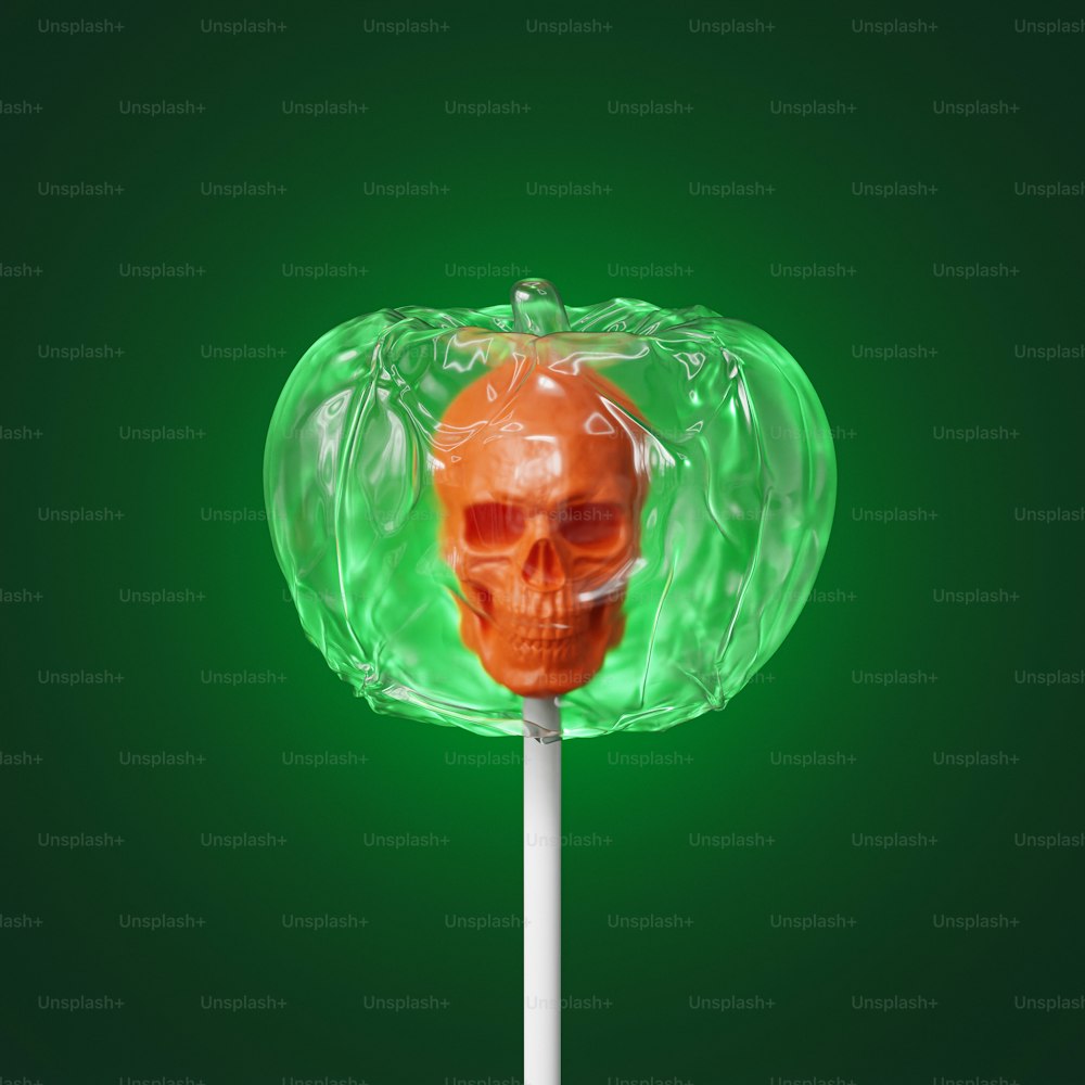 an orange skull lollipop on a green background