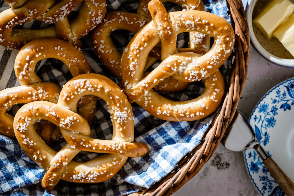 uma cesta cheia de pretzels ao lado de uma tigela de queijo