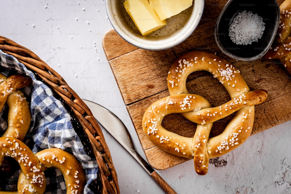 uma mesa coberta com pretzels ao lado de uma cesta de queijo