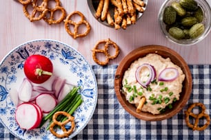 a table topped with plates of food and pretzels