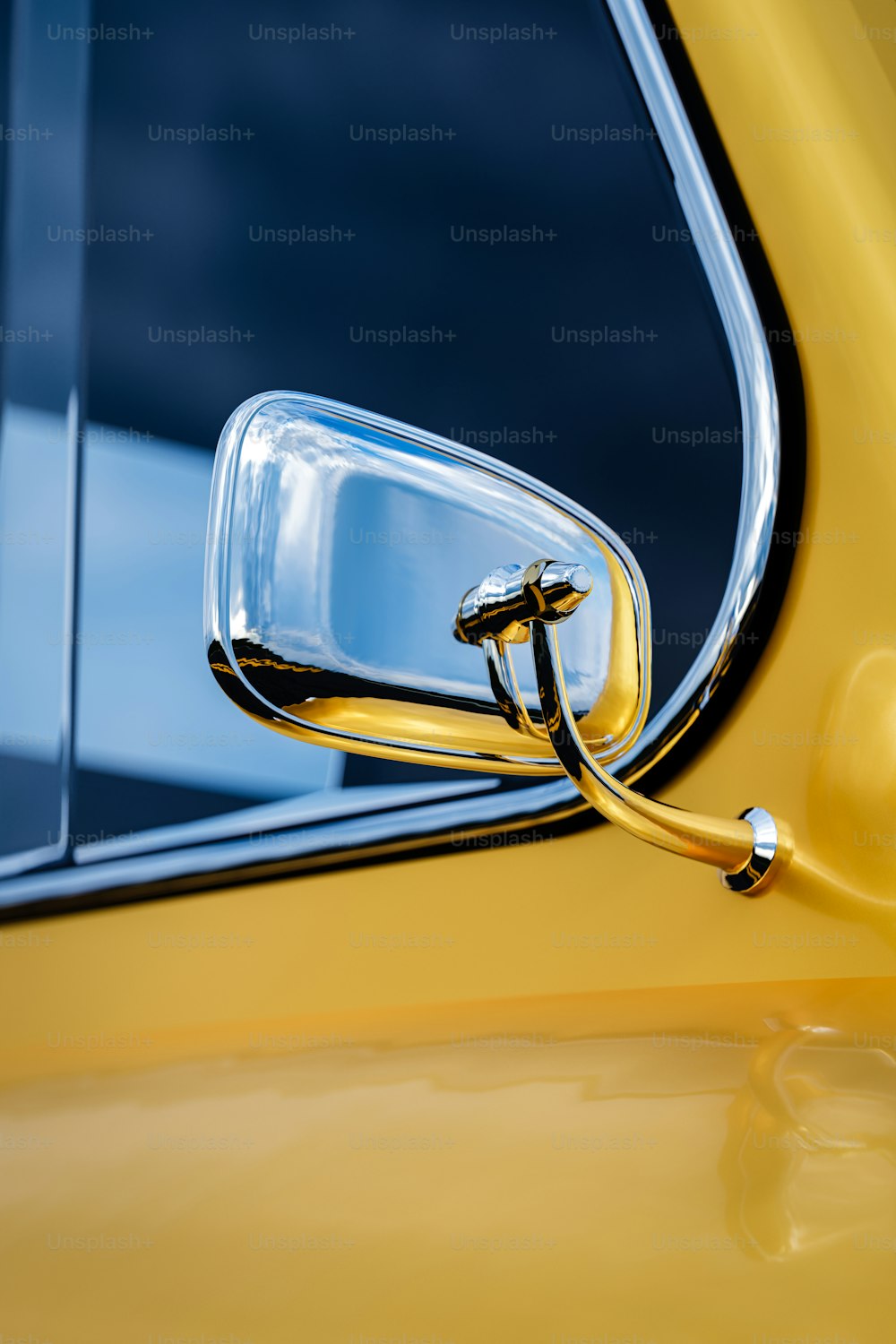 a close up of the side mirror of a yellow car