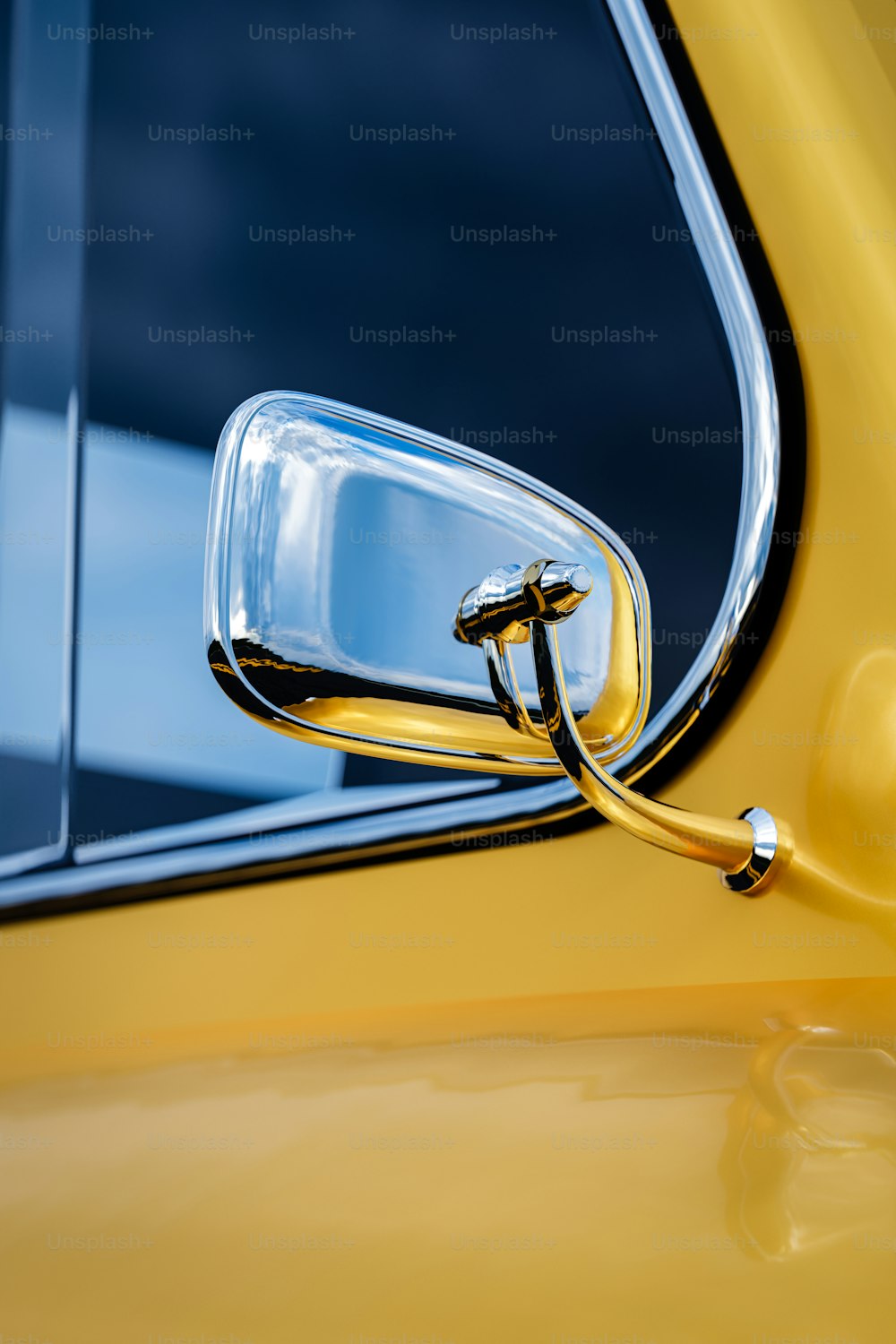 Nahaufnahme des Seitenspiegels eines gelben Autos