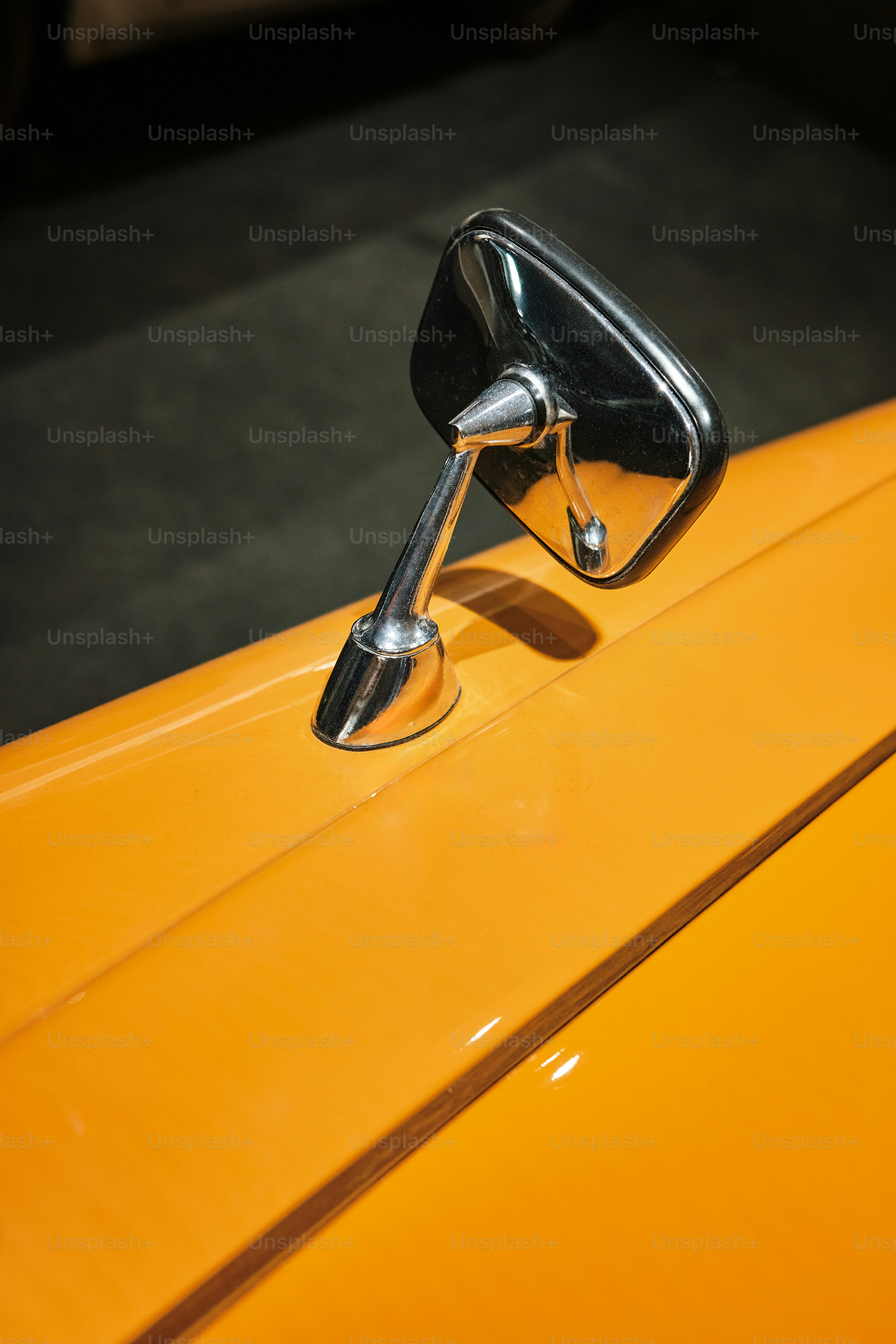 a close up of a mirror on a yellow car
