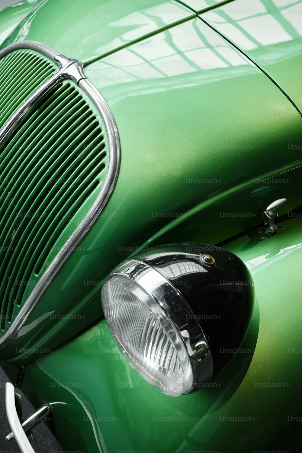 um close up da frente de um carro verde