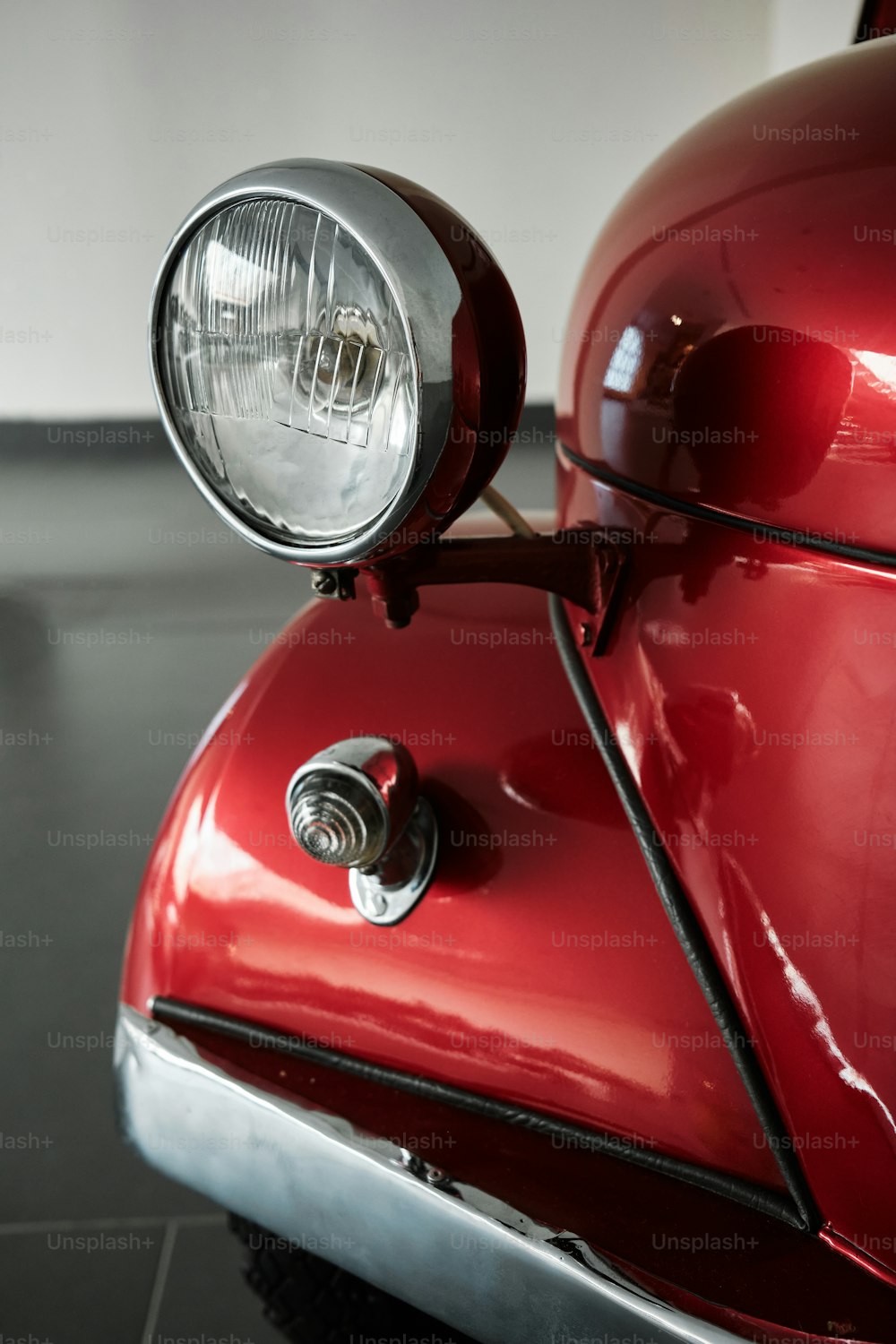 a close up of a shiny red car headlight