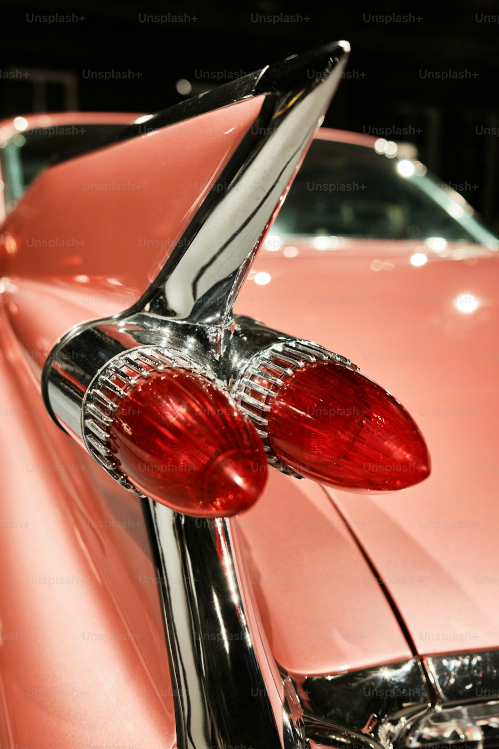 um close up das lanternas traseiras de um carro rosa