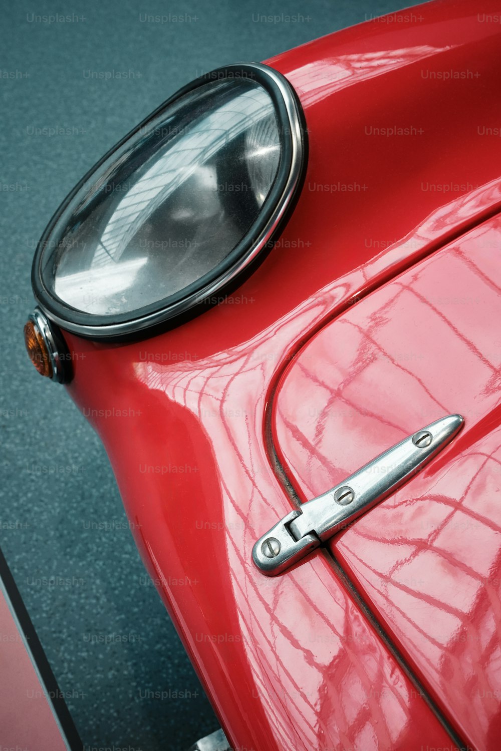 um close up da dianteira de um carro vermelho