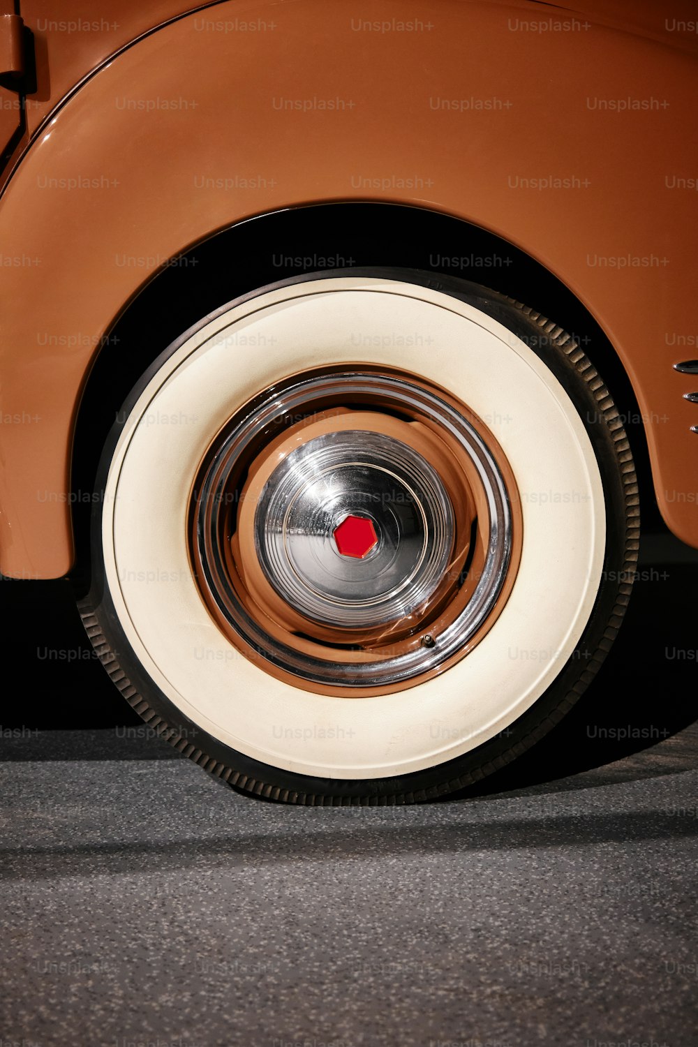 Un primer plano de un neumático de coche marrón y blanco