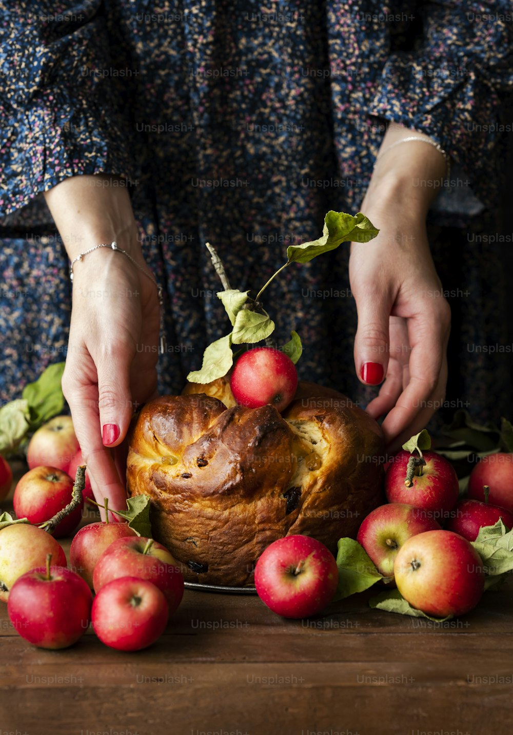a person placing apples on top of a loaf of bread