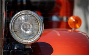 a close up of a headlight on a red car
