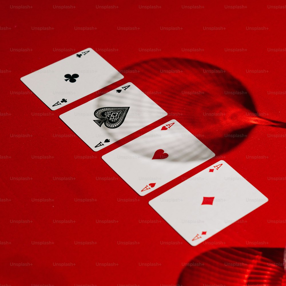 a red table topped with playing cards and a plastic spoon