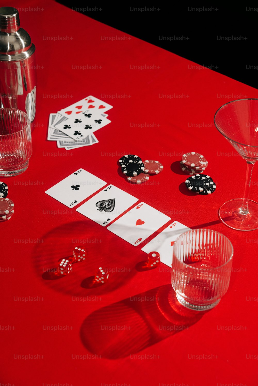 Una mesa roja cubierta con tarjetas y copas de vino