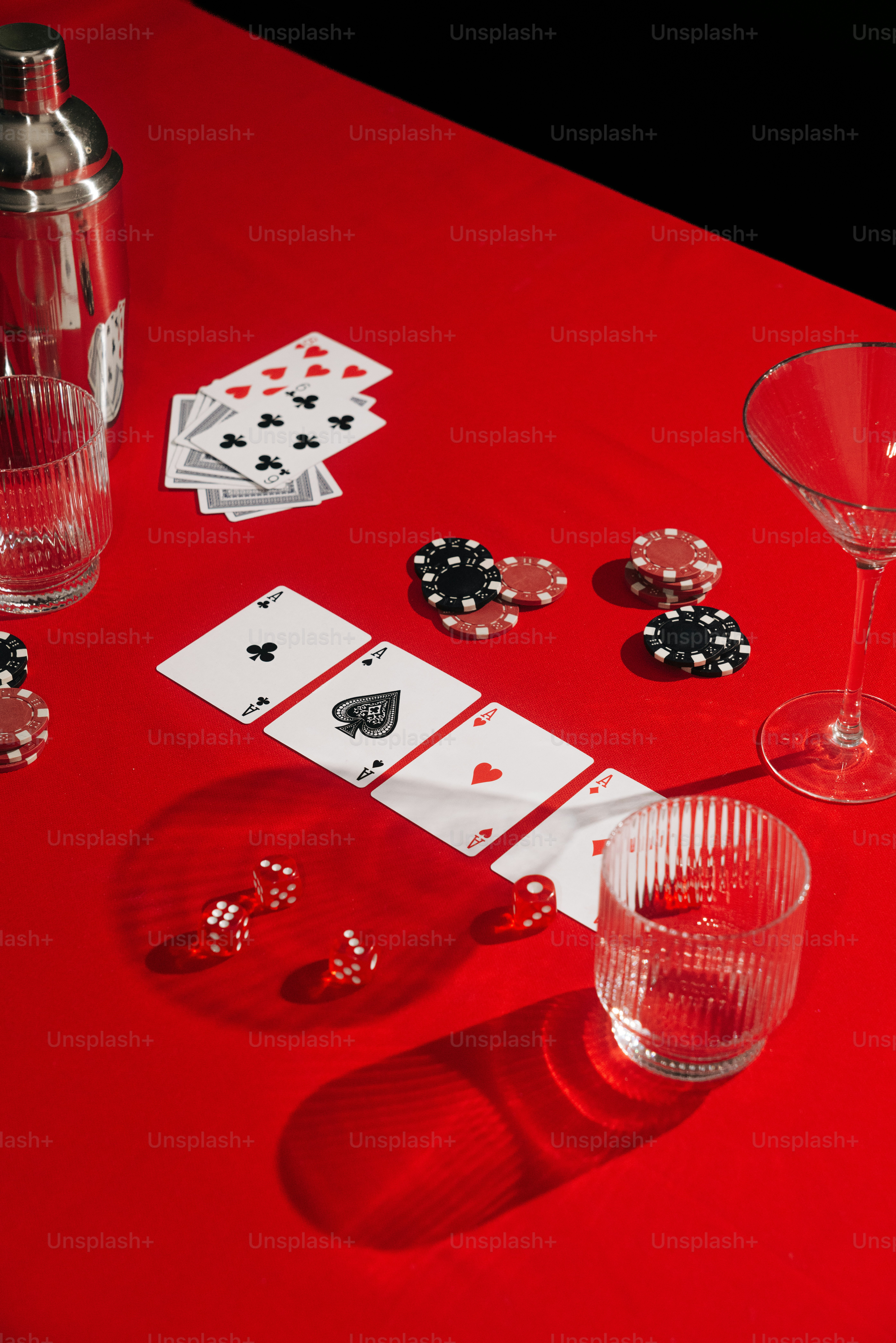 a red table topped with cards and wine glasses