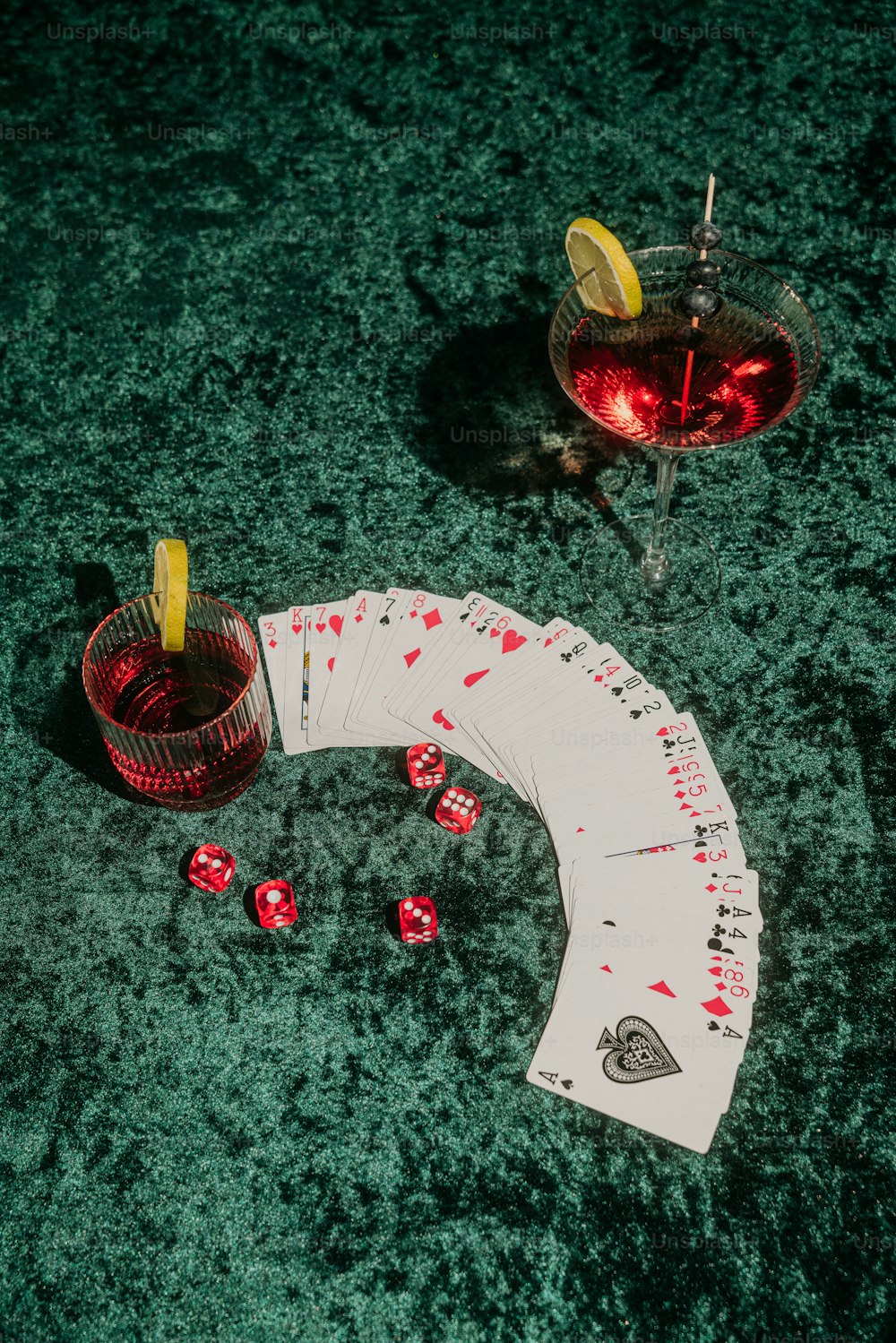 un tavolo sormontato da carte e un drink