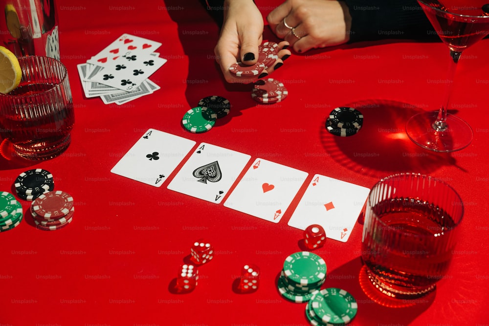 una mesa roja cubierta con tarjetas y copas de vino