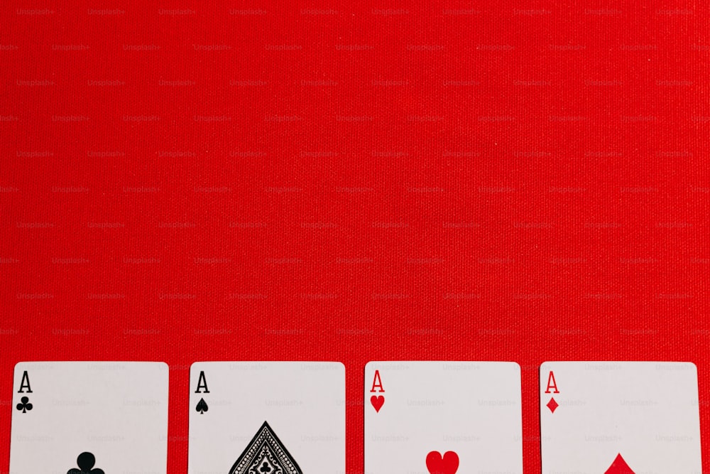 quattro di una specie di carte da gioco su uno sfondo rosso