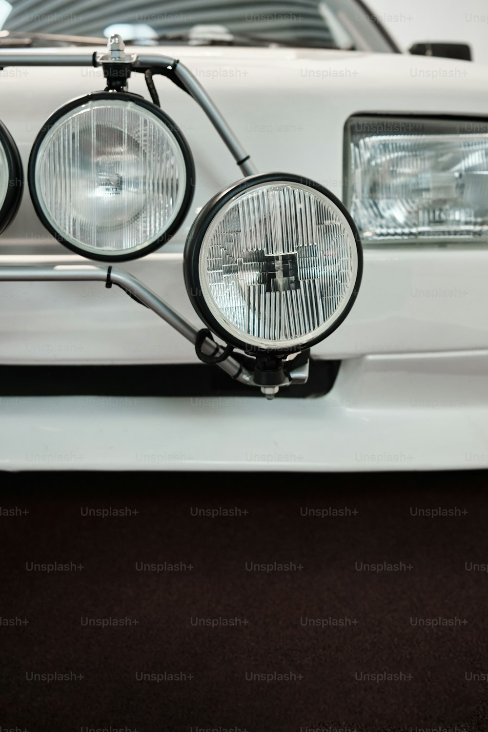 a close up of a white car with headlights